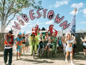 Group of people riding a stage bike with people in colorful outfits