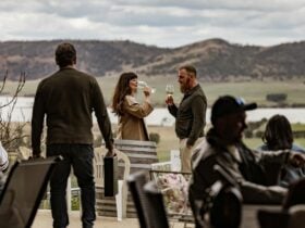 couple drinking wine with Coal River Valley in the background
