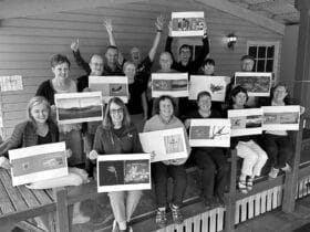 A group of people holding up photography books