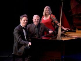 Three musicians pose with a black grand piano.