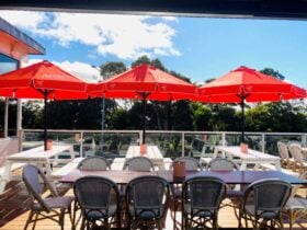 orange umbrealls, tables and chairs on sunny deck