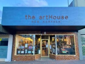 The exterior of the artHouse New Norfolk. Dark green signage with rusty metal letters over windows.