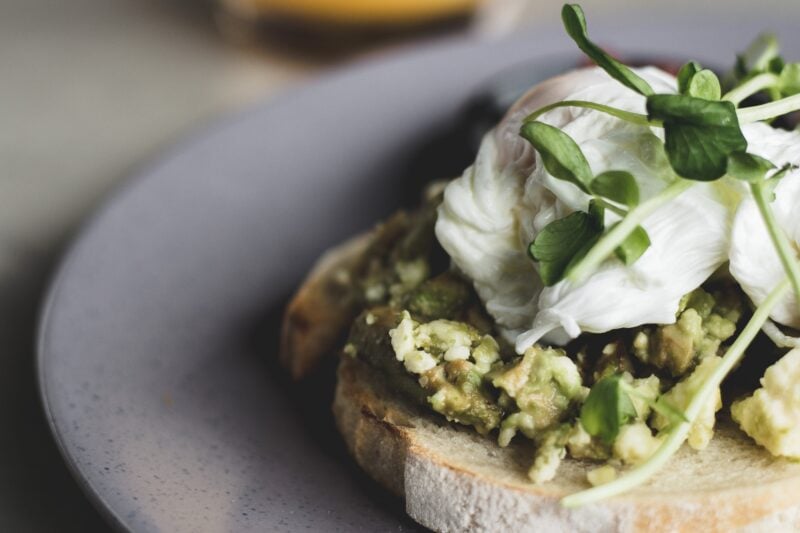 Close up image of poached eggs on smashed avocado, on sourdough toast.