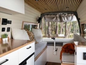 Premium campervan interior showcasing lounge seating and detailed wood craftsmanship.