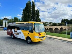 Coal River Valley Explorer Bus parked with the historic Richmond Bridge in the background