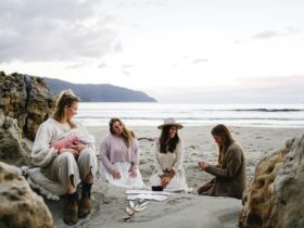 A small group of women sitting on a beach on the Tasman Peninsula, sharing a tarot reading together