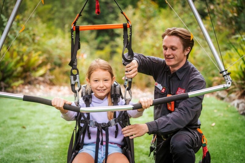 a child being safety harnessed by a Tahune Adventures guide