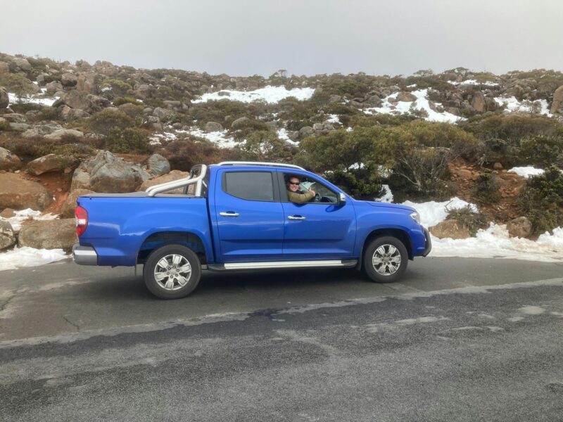 Matt, founder of Tascapades Tours, with the blue 4x4 tour vehicle in Tasmania