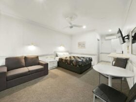 Standard Queen Room with bed, couch, table and television