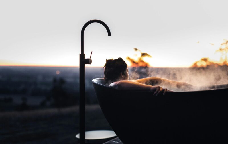 Outdoor bathtub overlooking rolling vineyard landscapes at a luxury Heathcote tiny home