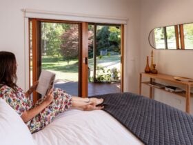 Guest relaxing on bed at Hume House Merrijig