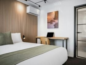 A queen sized room with a bed and desk