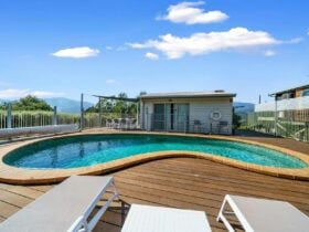 An outdoor swimming pool with decking and chairs around it