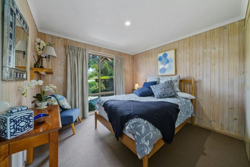 A bedroom with a bed, desk, and chair in the corner