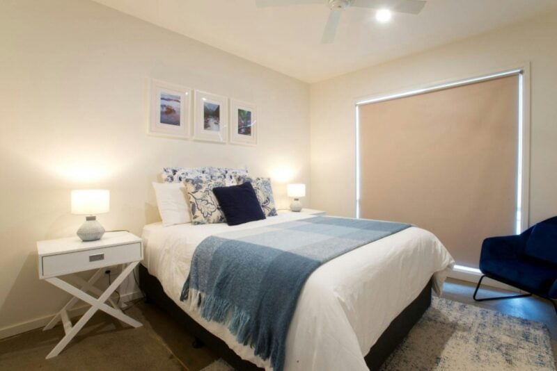 Bedroom one with a bed, blue chair and side table