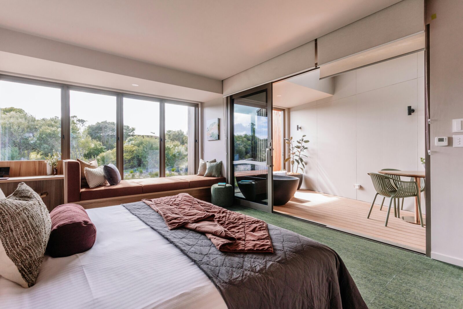 Eco Lodge interior with bed, dining table and bathtub