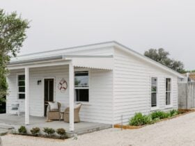 A white weatherboard cottage, looking into the front of the house from the driveway.
