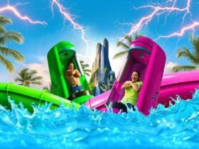 Two people in water slide capsules, surrounded by water