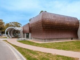 An image of the art gallery entrance through a small circular portal and the front of the building.