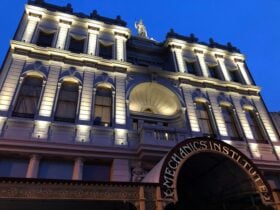 Facade of the BMI building at dusk with lights highlighting the pillars.