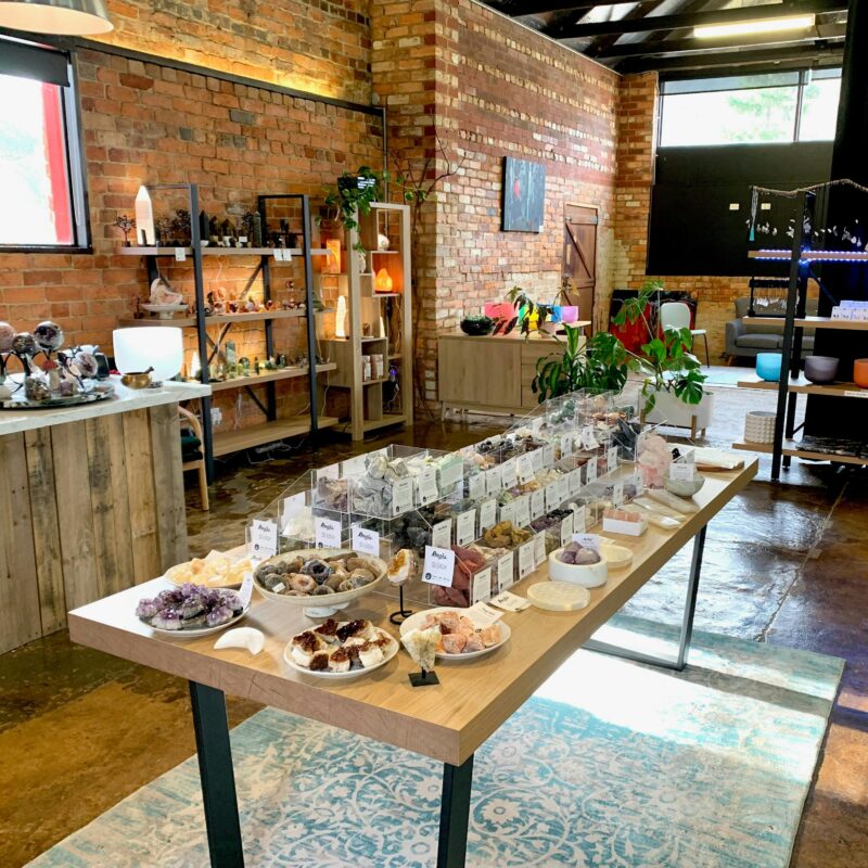 View into store of centre table with containers of crystals