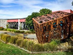 The outside of Caroline Springs Library, with a big metal cube sculpture in the foreground