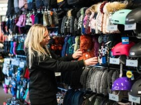 Women assessing winter stock, beanies and gloves