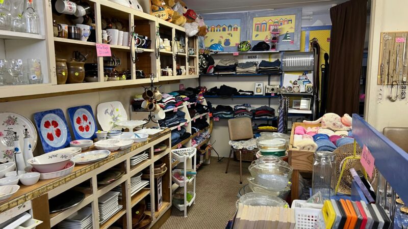 shelfs of clothes, crockery, glass bowls and knick knacks