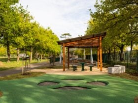 The inground trampolines next to a covered picnic table and benches