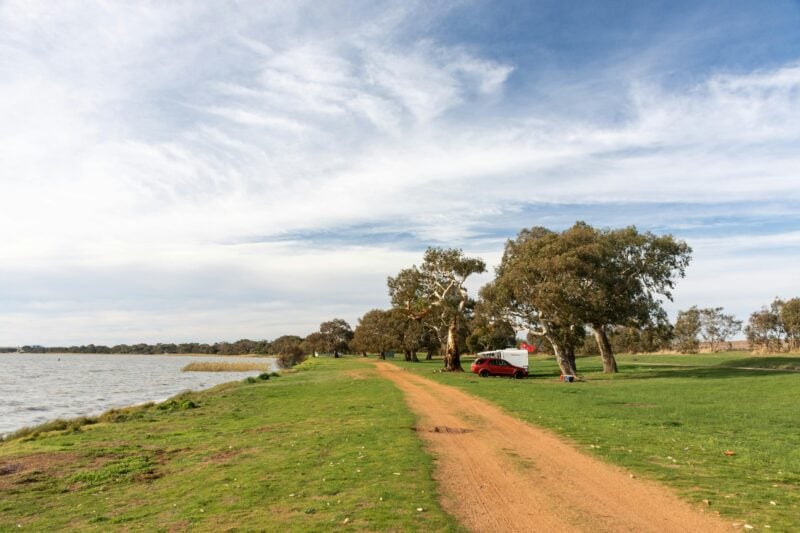 Grassy open campground beside a lake