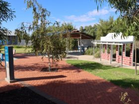 Paths, lawn and gardens plus barbeque shelter in background