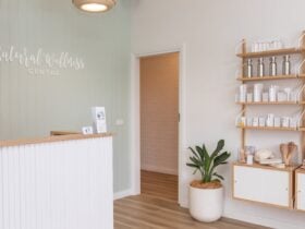 Reception desk, display shelves, plant in front of a light green panelled wall