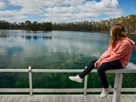 Girl sitting on pontoon overlooking lake