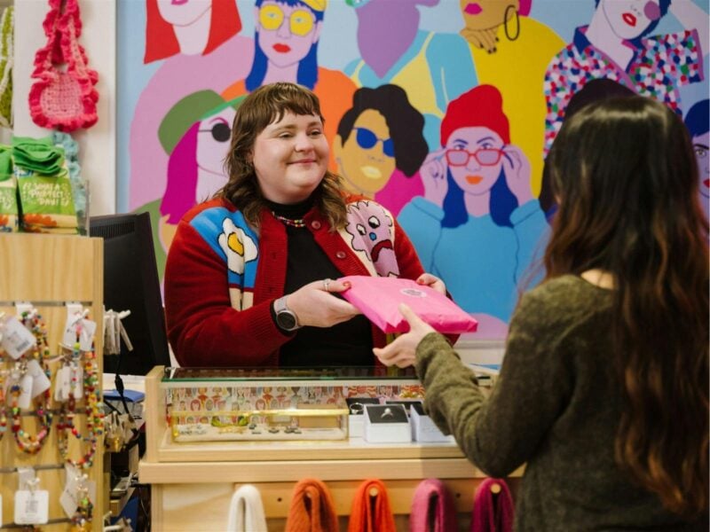 staff member handing rift wrapped purchase to customer
