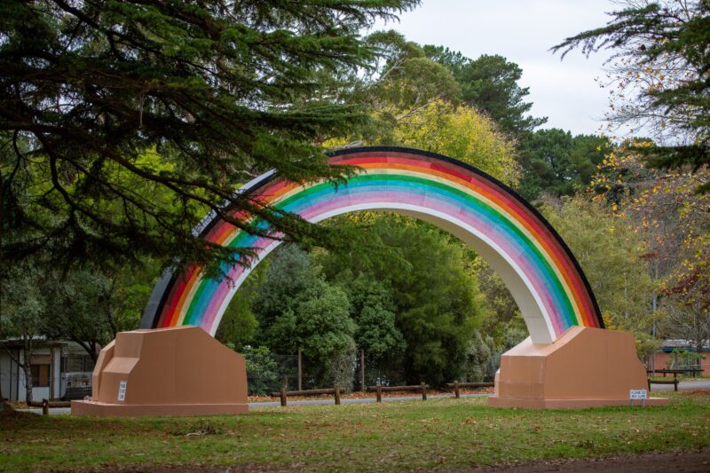 Big Rainbow public art in garden setting with trees