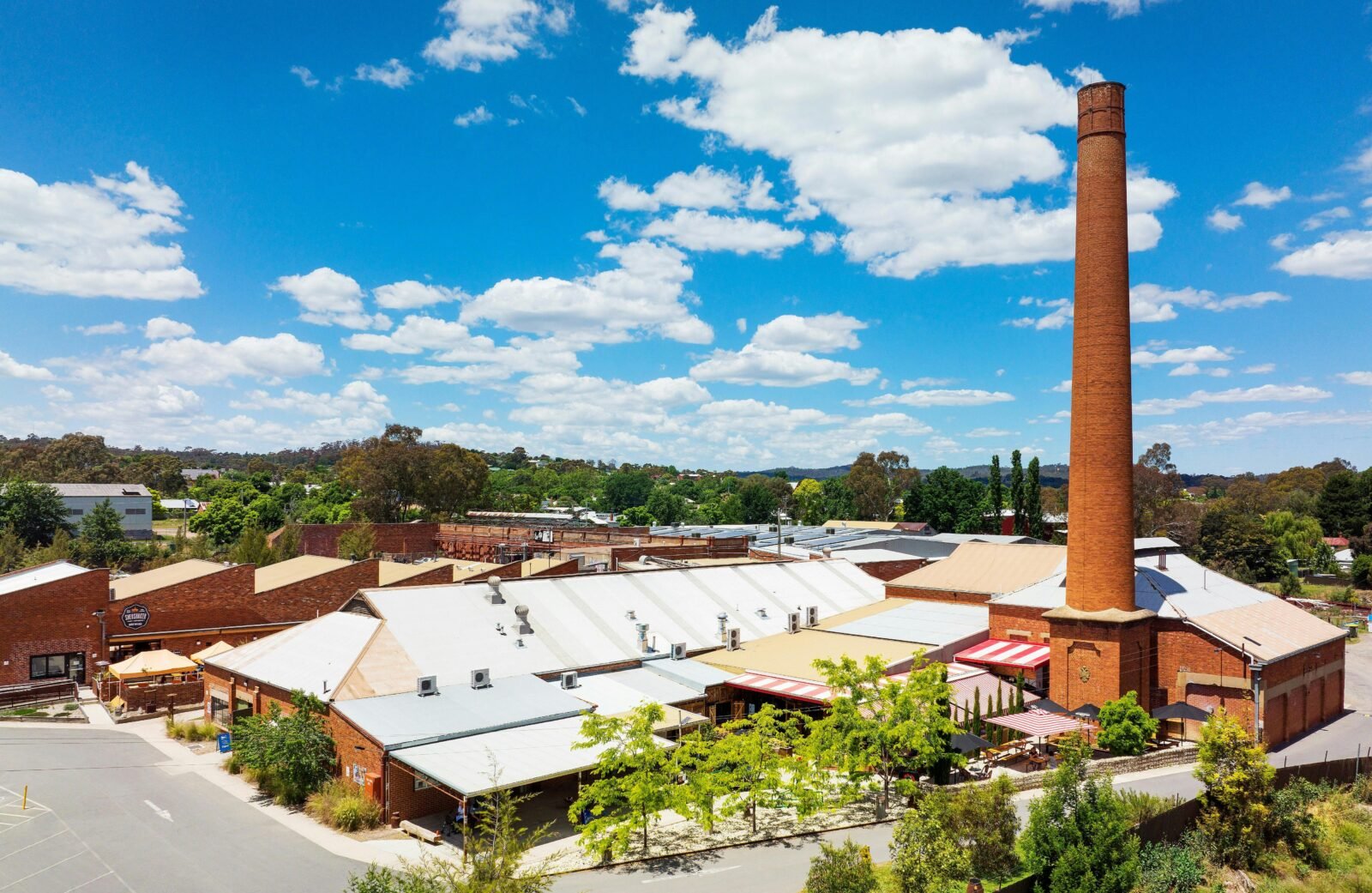 Aerial view looking at variety of old industrial buildings and chimney stack now home to businesses
