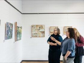 Three woman standing looking at a painting in our Kyneton Gallery