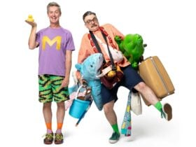 110% Ready cast holding a rubber duck along with a suitcase, plus toys and bucket full of items