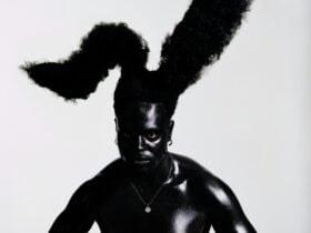 Self portrait, Campbell Addy. A black man looks directly at the camera. There is a grey background.