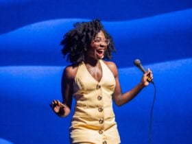 Anisa Nandaula performing on stage holding a microphone.