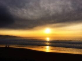Couple walking on the beach in Apollo Bay at sunset