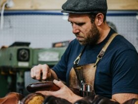 a person wearing a hat making shoes