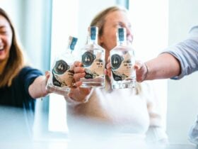 three-people-holding-bespoke-gin-bottles