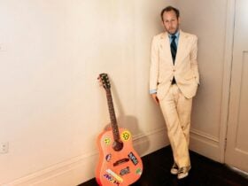 Ben Lee leaning on a wall with his guitar beside him ahead of his Kindred Bandroom show.