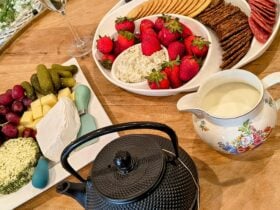Delicious fruits, cheeses, Savory biscuits, chocolate, teapot and jug of milk