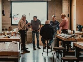 Five men inside a cane rod workshop talking