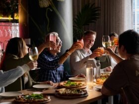 group of people raising their glasses in a dining table