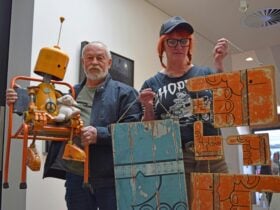 Photo of artists Robert Liston (left) and Jacki Irwin showing some of their upcycled artwork
