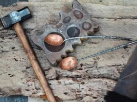 Copper serving utensils resting on bench with hammer