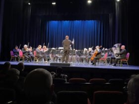 Conductor and members of the orchestra getting ready to play.